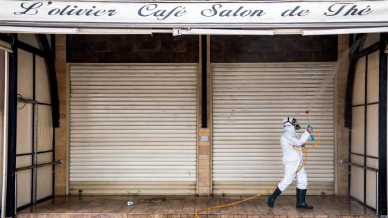 A Moroccan health ministry worker disinfects the entrance of a closed-down cafe in the capital Rabat on March 22, 2020. - A public health state of emergency went into effect in the Muslim-majority country late on March 20, and security forces and the army have been deployed on the streets to combat the spread of COVID-19 coronavirus disease. People have been ordered to stay at home, and restrictions on public transport and travel between cities are also in place. (Photo by FADEL SENNA / AFP) (Photo by FADEL SENNA/AFP via Getty Images)
